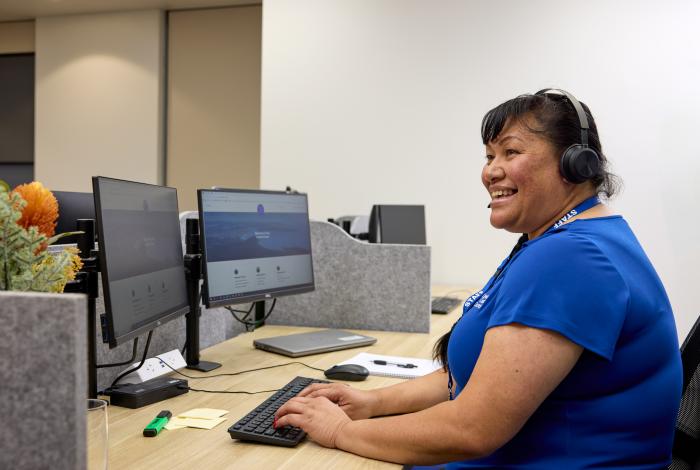 Woman at computer with headset on smiling